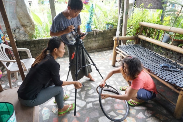 3 young people use a tripod and mini camcorder to film how to cut apart a bike tyre